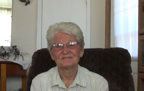 An image of Deon Harvey, sitting in a chair, in her home, on November 20, 2015